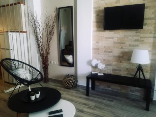 a living room with a television on a brick wall at Christina Apartments in Fourka