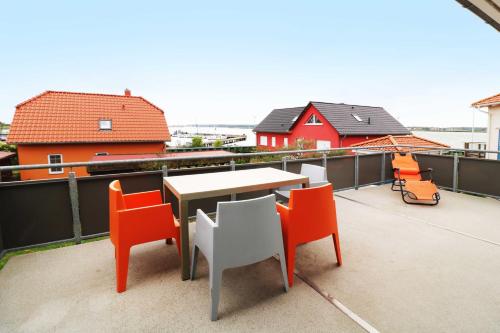 a patio with a table and chairs on a roof at Ferienwohnung Leuchtfeuer 6 OG_ RO in Peenemünde