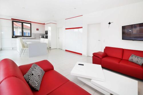 a living room with a red couch and a table at Ferienwohnung Leuchtfeuer 6 OG_ RO in Peenemünde