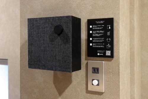 a wall with a remote control and an electrical switch at BUNSHODO HOTEL in Fukuoka