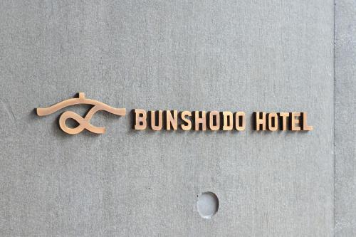 a sign for a buitschko hotel with a pair of scissors at BUNSHODO HOTEL in Fukuoka