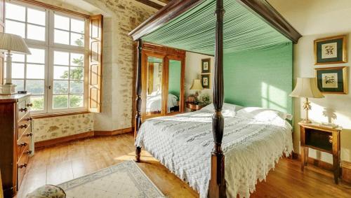 a bedroom with a canopy bed and a window at 14th Century Priory in Pressigny in Pressigny