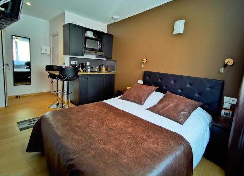 a bedroom with a large bed and a kitchen at Appart Hotel Relax Spa in Lens