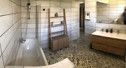 une salle de bain avec une baignoire et un lavabo dans l'établissement Loft Rêve du Soir 125 m2 climatisé 350 m de la gare, à Lourdes