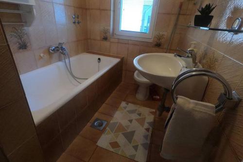 ein Badezimmer mit einer Badewanne, einem Waschbecken und einem WC in der Unterkunft Apartma Kreda in Mojstrana