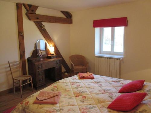 sypialnia z łóżkiem z czerwonymi poduszkami w obiekcie LA GRANGE w mieście Saint-Prix-lès-Arnay