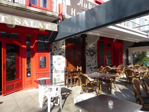 een terras met tafels en stoelen voor een restaurant bij Auberge du Haut Salat in Seix