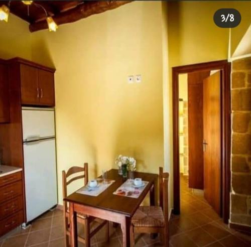 Il comprend une cuisine avec une table et des chaises. dans l'établissement Luxurious Stone Apartment 2, à Kerá
