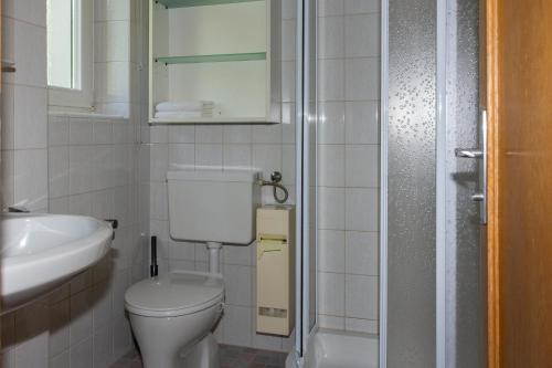 a white bathroom with a toilet and a sink at Ferienwohnung Elfriede in Hopfgarten in Defereggen