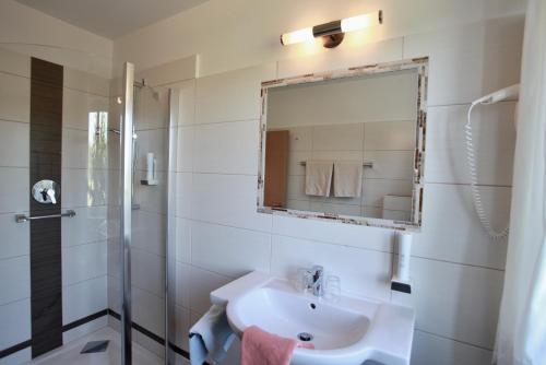 a bathroom with a sink and a shower and a mirror at Hotel-Restaurant am Hochfuchs in Eugendorf