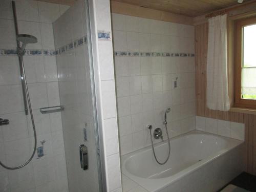 y baño con bañera y ducha con cortina de ducha. en Naturparadies Silvia en Alberschwende
