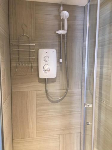 W łazience z przeszklonymi drzwiami znajduje się prysznic. w obiekcie Harepath Farm Cottages 2 w mieście Exeter