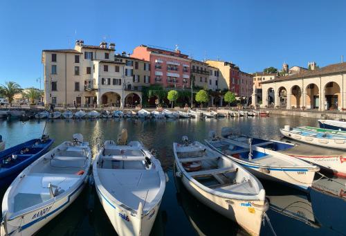 um grupo de barcos está ancorado num porto em Hotel Piroscafo em Desenzano del Garda