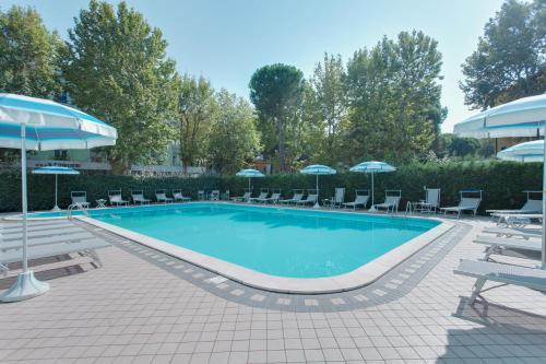 a large swimming pool with chairs and umbrellas at Hotel Bella Zurigo in Cesenatico