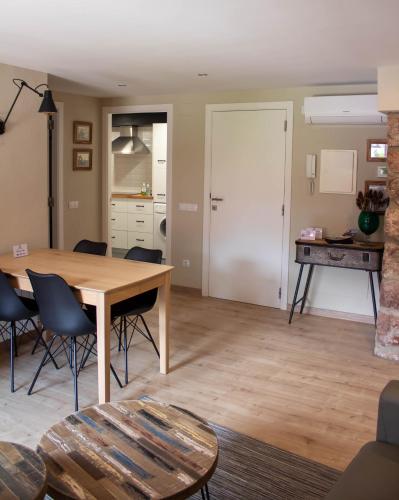 a living room with a table and chairs and a kitchen at Cal Tomaset in Prades