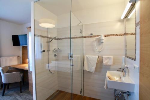 a bathroom with a glass shower and a sink at Hotel-Restaurant am Hochfuchs in Eugendorf