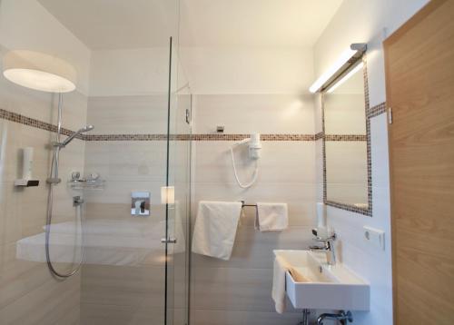 a bathroom with a glass shower and a sink at Hotel-Restaurant am Hochfuchs in Eugendorf
