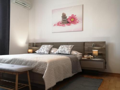 a bedroom with a bed and a picture on the wall at Apartment & Rooms Graciela in Rovinj