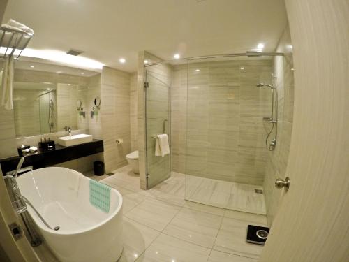 a bathroom with a shower and a toilet and a sink at UCSI Hotel Kuching in Kuching