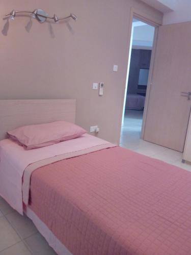 a bedroom with a bed with a pink blanket at 3 Bedroom Apartment in Nicosia