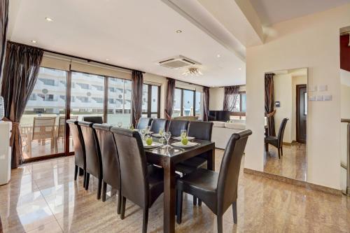 a dining room with a table and black chairs at Seafront Protaras Villas in Protaras