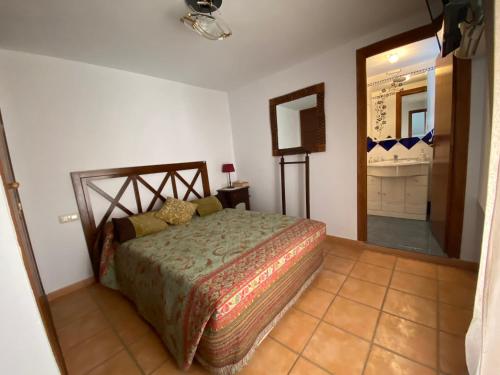 1 dormitorio con 1 cama en una habitación con espejo en APARTAMENTO RURAL CASA MONTE, en Cazalla de la Sierra