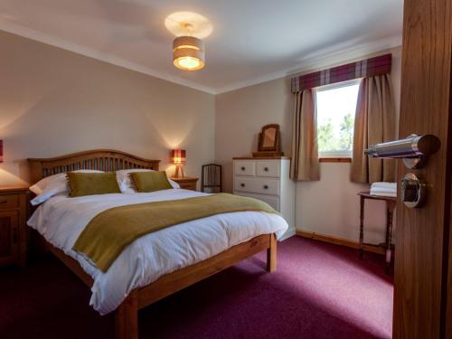 a bedroom with a bed, a lamp, and a dresser at The Birches Bed & Breakfast in Dundonnell