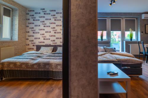 a bedroom with two beds and a table at JDK Apartamenty Legionów 50m2 5-osobowy in Kalisz