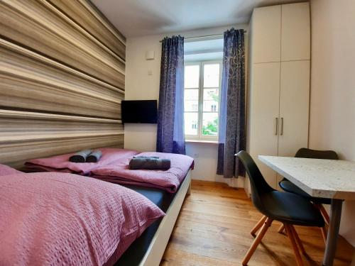 een slaapkamer met 2 bedden, een tafel en een bureau bij Apartment Silver in Ljubljana