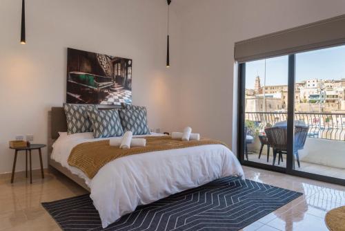 um quarto com uma cama grande e uma varanda em Vittoriosa' Seafront 2 Bed Highly Furnished Apartment em Vittoriosa