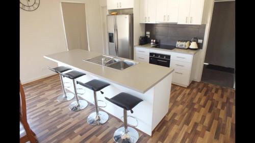 a kitchen with a counter with stools and a sink at Gone skiing in Bonnie Doon