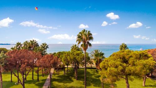 a view of a park with palm trees and the ocean at Acanthus Cennet Barut Collection - Ultra All Inclusive in Side