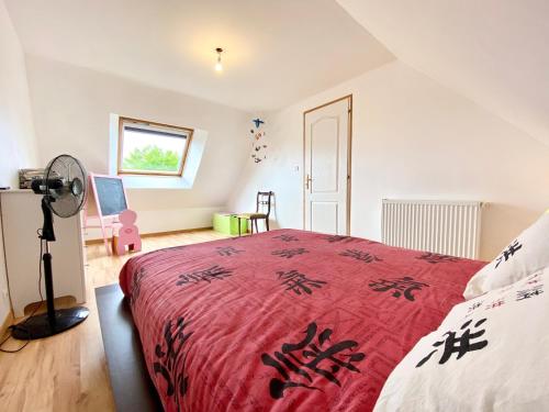 ein Schlafzimmer mit einem roten Bett und einem Fenster in der Unterkunft Jolie maison récente confort Proche des plages in Riantec
