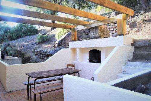 um pátio com uma mesa e uma lareira em le relais de tiuccia em Casaglione