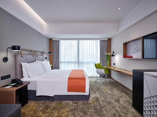 a hotel room with a large bed and a television at Holiday Inn Guangzhou South Lake, an IHG Hotel-Free shuttle bus to Canton Fair Complex during Canton Fair Period in Guangzhou