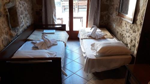 Dos camas en una habitación con toallas. en Luxurious Stone Apartment 1, en Rókka
