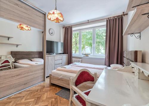 Cette chambre comprend 2 lits et un miroir. dans l'établissement Mieszkanie Next - NoclegiSopot, à Sopot