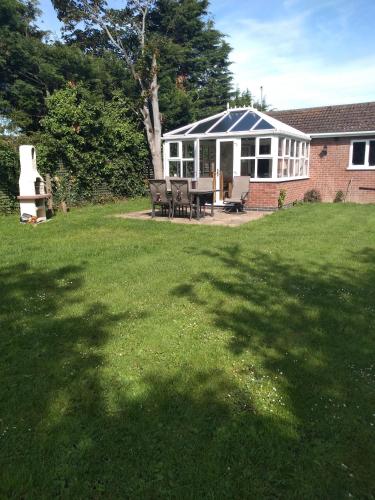 a yard with a house with a table and chairs at Rosedene in Mablethorpe