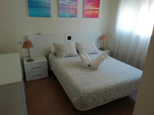 a bedroom with a bed with a white chair on it at Apartamento en rota in Rota