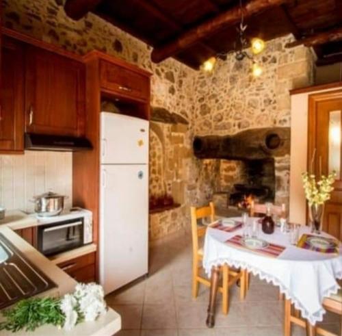 a kitchen with a table and a white refrigerator at Luxurious Stone Apartment 1 in Rókka