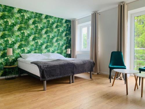 - une chambre avec un lit et un mur vert dans l'établissement Cały dom w Mielnie!, à Mielno