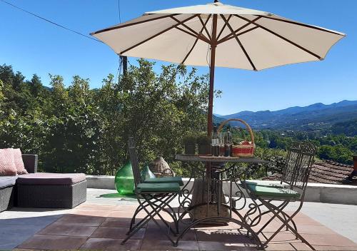 a table and chairs with an umbrella on a patio at Casa Valtaro in Borgo Val di Taro