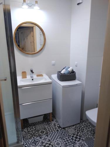 y baño con lavabo y espejo. en Nowy Apartament Bałtycka 11, en Kołobrzeg
