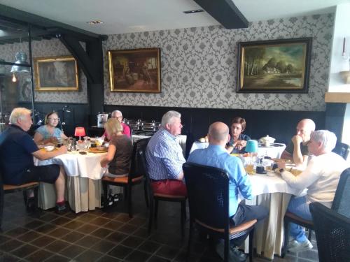 a group of people sitting at tables in a restaurant at Gasthof Maerlant in Damme