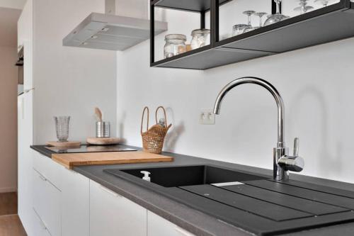 uma cozinha com um lavatório preto e um balcão em City PENTHOUSE, rooftop terrace, free NETFLIX, wifi and airco em Antuérpia