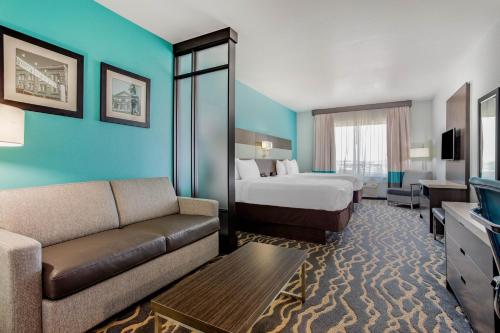 La Quinta Inn & Suites by Wyndham Northlake Ft. Worth في Northlake: غرفه فندقيه بسرير واريكه