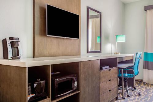 a hotel room with a flat screen tv on a wall at La Quinta Inn & Suites by Wyndham Northlake Ft. Worth in Northlake