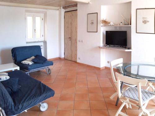 salon z niebieską kanapą i szklanym stołem w obiekcie Appartamento elegante a Marina di Campo w mieście Campo nell'Elba