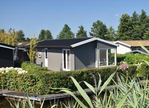 a small house with a garden in front of it at Chalet nr. 9 Resort Venetië in Giethoorn
