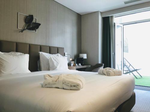 a bedroom with a large bed with towels on it at The Leaf Boutique Hotel Lisbon - Adults Only in Lisbon